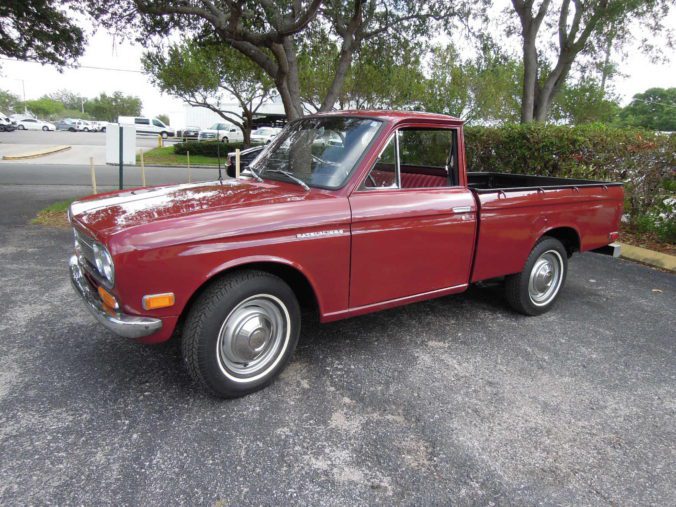 Vintage red Datsun pickup truck side view